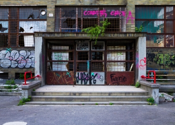 56389400 - entrance of an abandoned building covered in colorful graffiti