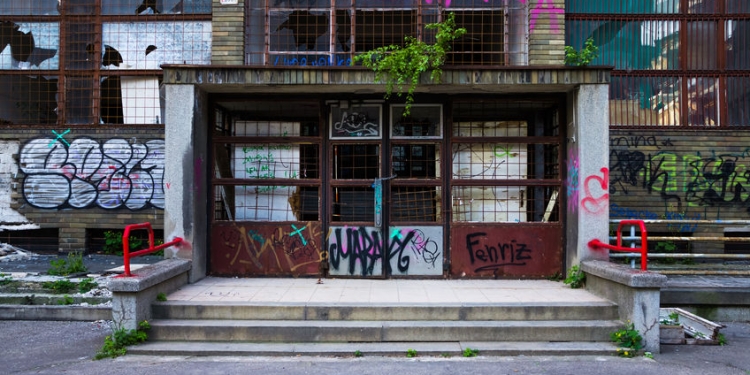 56389400 - entrance of an abandoned building covered in colorful graffiti
