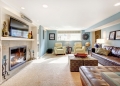 25561339 - light blue living room with leather furniture set, beige carpet floor, tv and fireplace
