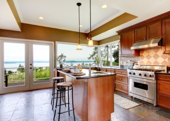 13888935 - luxury kitchen interior with green walls and stone floor and water view.
