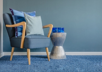 37699196 - wooden chair with blue color pillow on carpet in living room