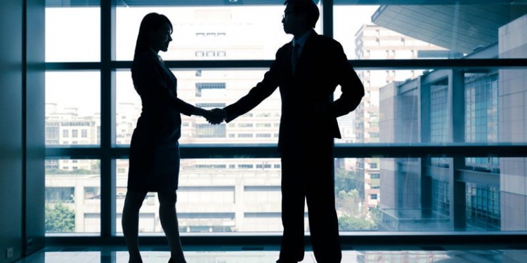 27342987 - successful business woman and man handshaking with office building
