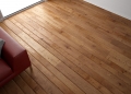 30533035 - wooden floor texture with red leather couch and pillow