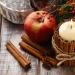 Candle decorated with cinnamon sticks and red apples, christmas decoration